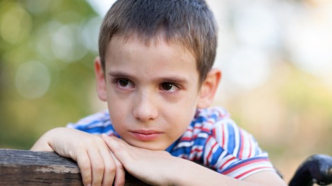 A ADHD young boy with anxiety crying outdoors