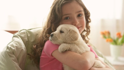 Young child hugging a puppy to help calm anxiety