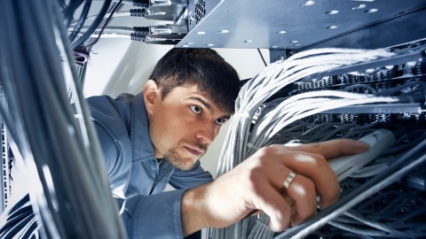 A computer technician with ADHD works on an enterprise level server.