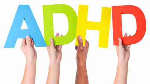 A group of ADHD adults proudly hold up a sign to indicate that ADHD is real.