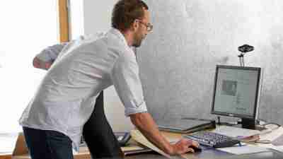 An employee maintains his attention by standing, helping master his ADHD in the workplace.