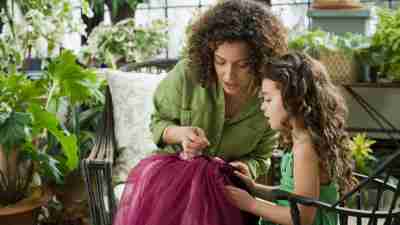 Mother teaching her daughter sewing over summer to prevent learning loss