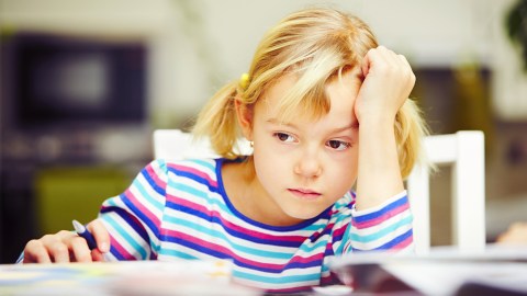 A young student working intently on a long term project to avoid the homework stress of racing to meet deadlines.