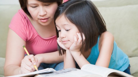 A mother and daughter work on math problems together, relieving homework stress with teamwork.