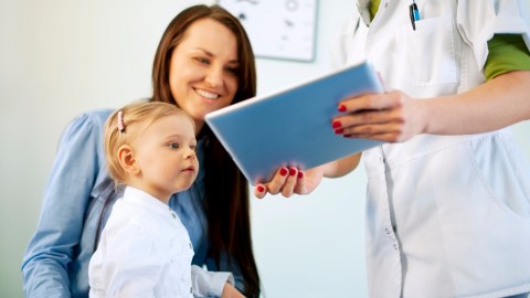 A woman with ADHD looks at a doctor's tablet.