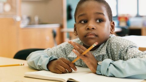 An apprehensive student contemplating his writing assignment, which 504 accomodations for adhd can help manage.