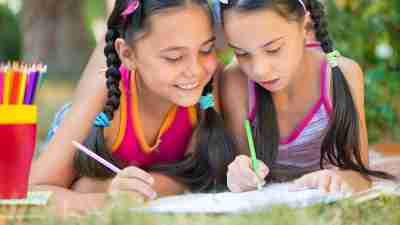 Two girls drawing together to avoid summer learning loss