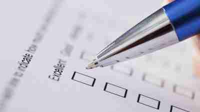 Hand of teacher checking off "excellent" from options for ADHD rating scale test