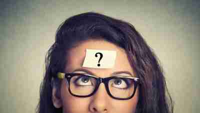 Woman with question mark on her head wonders about her ADHD and its connections to learning disabilities