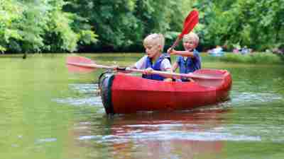 Two boys with ADHD kayaking on lake at summer camp