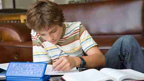 A teenage boy with ADHD doing homework in the living room